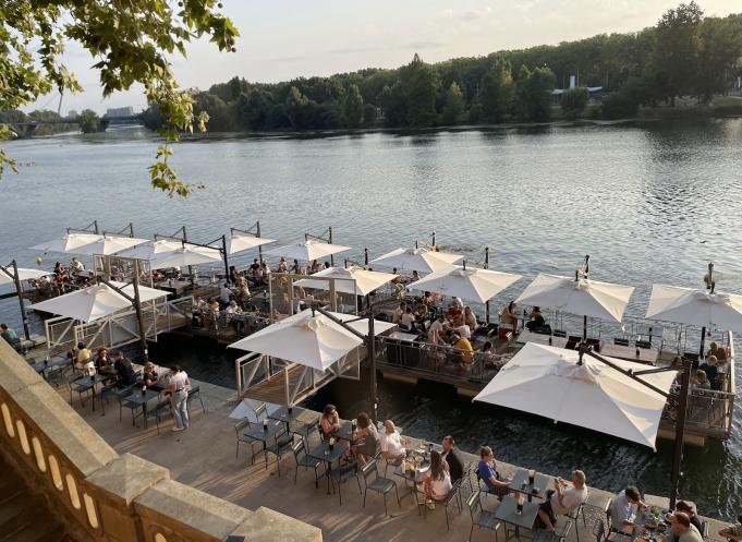 Avec sa deuxième saison, Les Canotiers affirment leur ancrage dans le paysage toulousain estival. Ni tout à fait bar, ni tout à fait restaurant, mais un peu des deux à la fois, cette guinguette flottante s’inscrit comme un lieu unique, au croisement du patrimoine, de la gastronomie et de l’art de vivre. (Photo Les Canotiers)